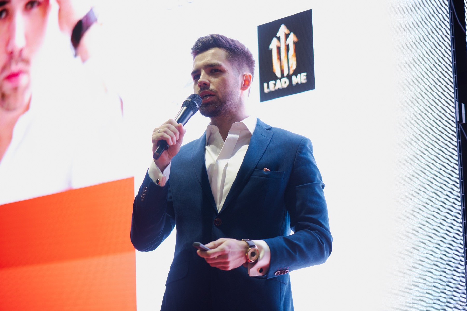 Patryk Czerniejewski prowadzi wystąpienie na scenie.